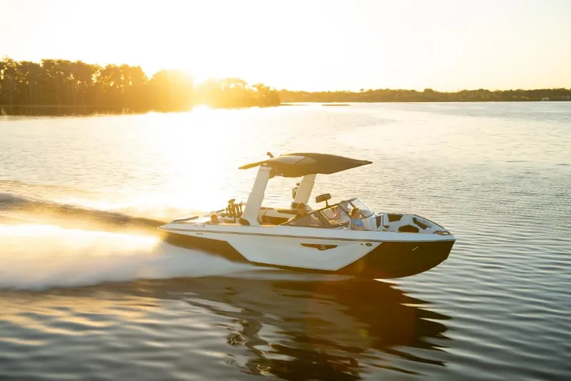 Slide: The Image of 2023 Nautique Super Air Nautique S25 speedboat cruising on a lake at sunset. - 42