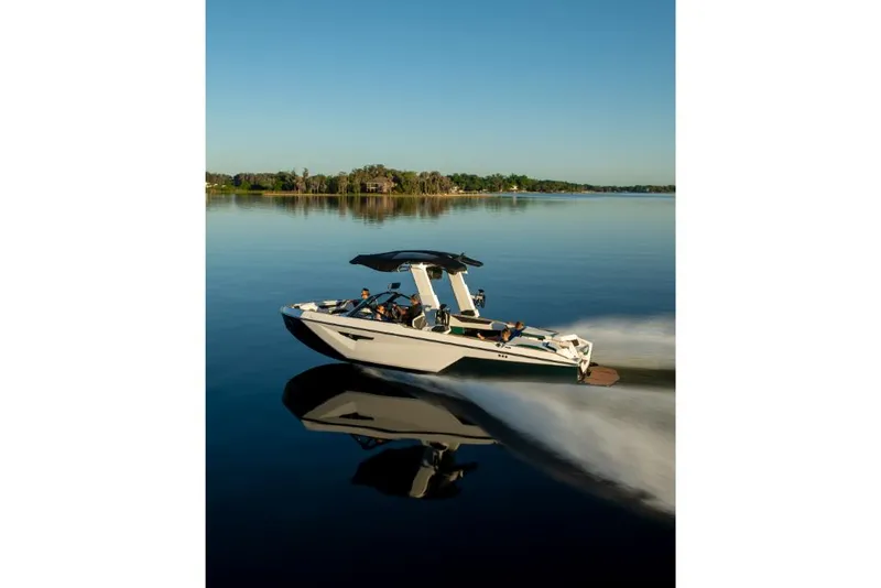 Slide: The Image of 2023 Nautique Super Air Nautique S25 boat cruising on a calm lake. - 46