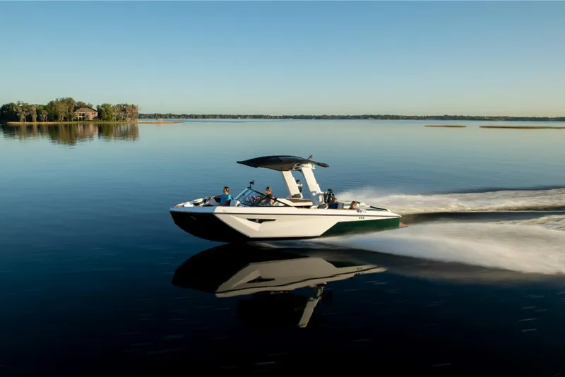 Slide: The Image of 2023 Nautique Super Air Nautique S25 cruising on a calm lake. - 49