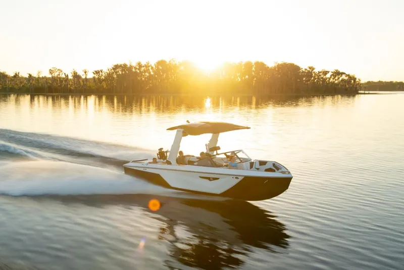 Slide: The Image of 2023 Nautique Super Air Nautique S25 boat cruising on a lake at sunset. - 6