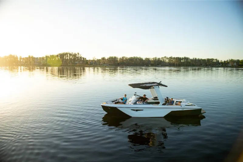 Slide: The Image of 2023 Nautique Super Air Nautique S25 boat on a calm lake at sunset. - 7