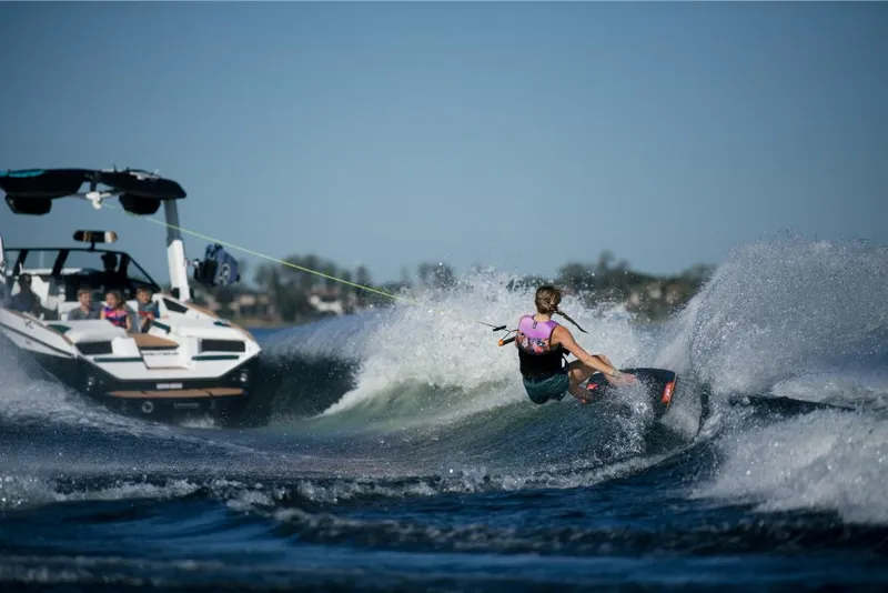 Slide: The Image of Person wakeboarding behind a 2023 Nautique Super Air Nautique S25 boat. - 9