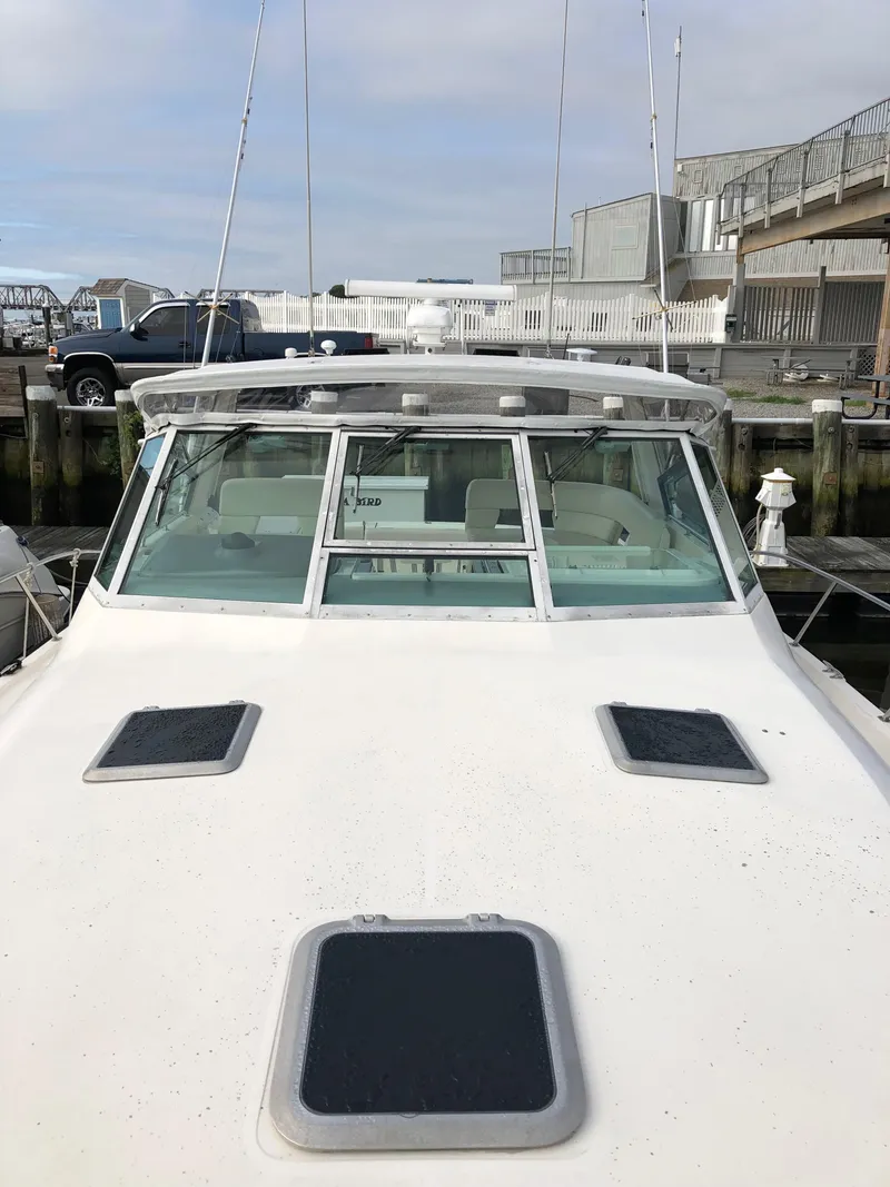 Slide: The Image of 1997 Tiara Yachts 3700 Open docked, showcasing front deck and windshield. - 12