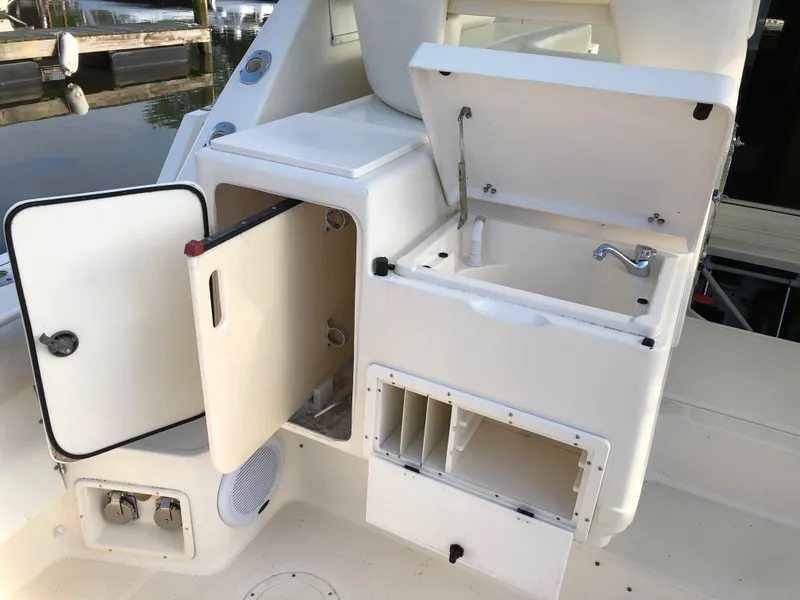 Slide: The Image of 1997 Tiara Yachts 3700 Open boat interior with open storage compartments and sink. - 15