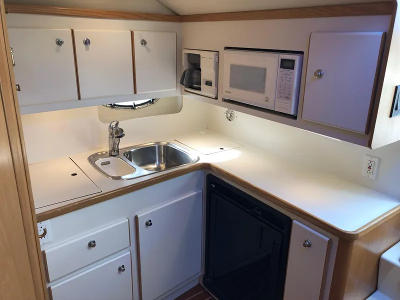 Slide: The Image of 1997 Tiara Yachts 3700 Open kitchen with sink, microwave, and cabinets. - 30