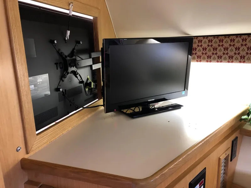 Slide: The Image of 1997 Tiara Yachts 3700 Open interior with mounted flat-screen TV on wooden cabinetry. - 37