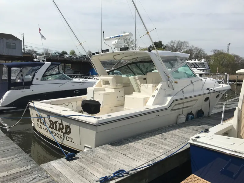 Slide: The Image of 1997 Tiara Yachts 3700 Open docked at marina, featuring spacious deck and sleek design. - 4