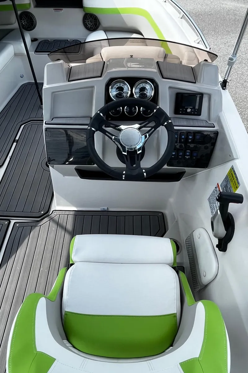 Slide: The Image of 2024 Starcraft SVX 191 boat cockpit with steering wheel and green-accented seating. - 5