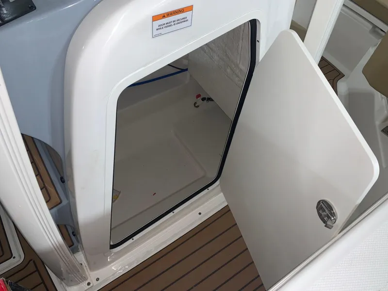 Slide: The Image of 2024 Bayliner Trophy 20CX storage compartment with open door. - 12