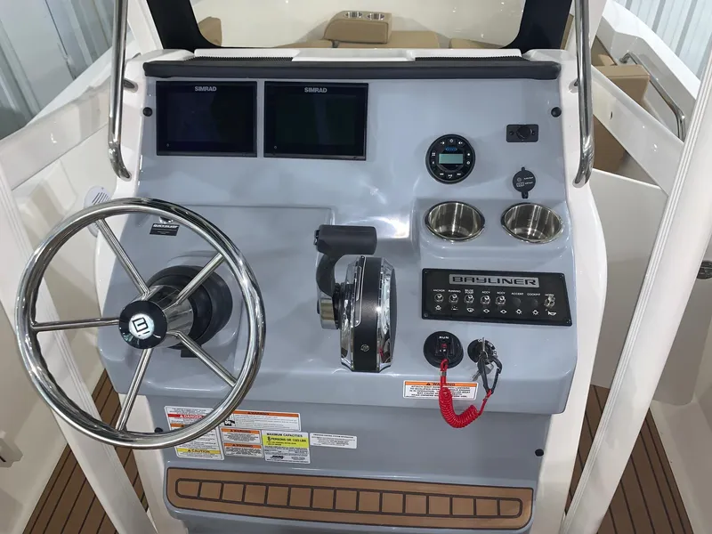 Slide: The Image of 2024 Bayliner Trophy 20CX boat dashboard with steering wheel and control panel. - 6