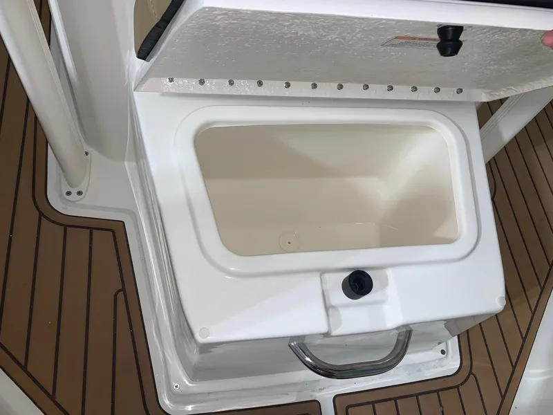 Slide: The Image of 2024 Bayliner Trophy 20CX storage compartment with open lid. - 13