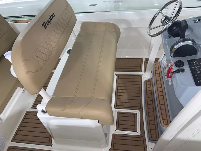 Slide: The Image of 2024 Bayliner Trophy 20CX boat interior with tan seating and wood-patterned flooring. - 7