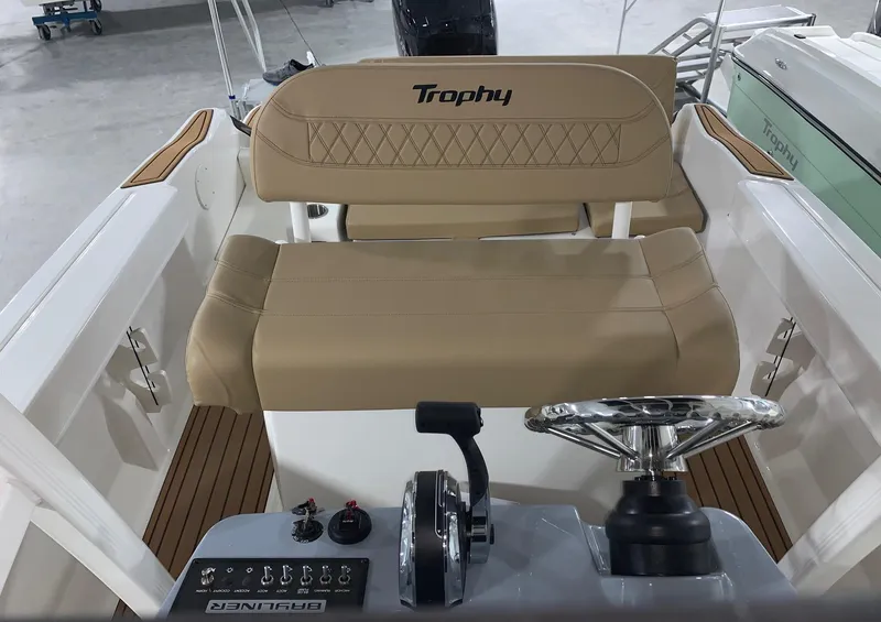 Slide: The Image of 2024 Bayliner Trophy 20CX boat interior with beige seating and steering console. - 8
