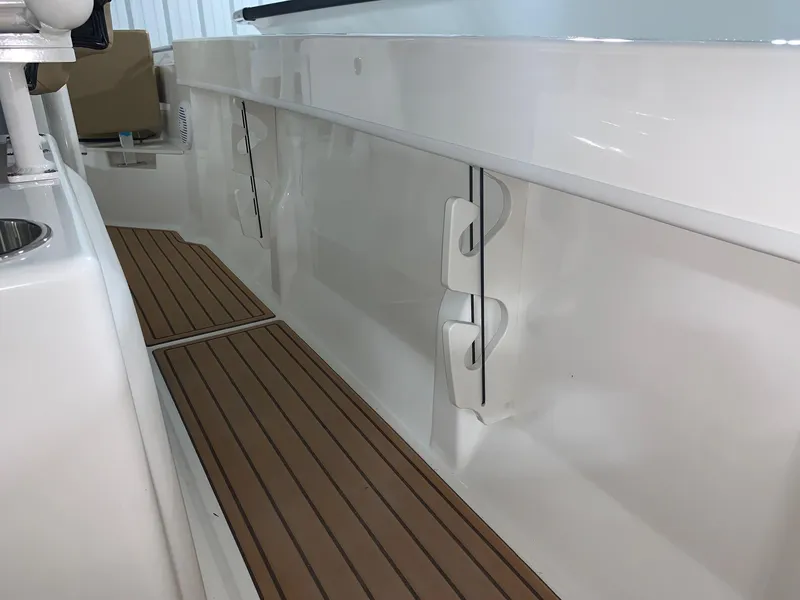 Slide: The Image of 2024 Bayliner Trophy 20CX boat interior with teak flooring and white side panels. - 9