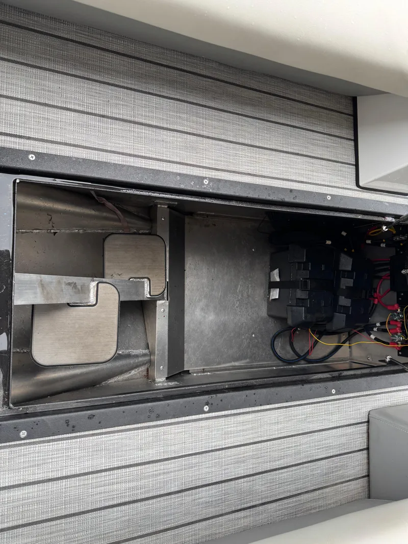 Slide: The Image of Interior view of a 2022 Montara SURF BOSS 25 boat, showcasing storage and wiring. - 13