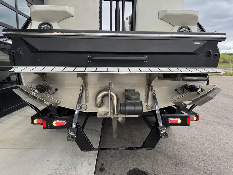 Slide: The Image of Rear view of 2022 Montara SURF BOSS 25 boat, showcasing engine and trim tabs. - 4