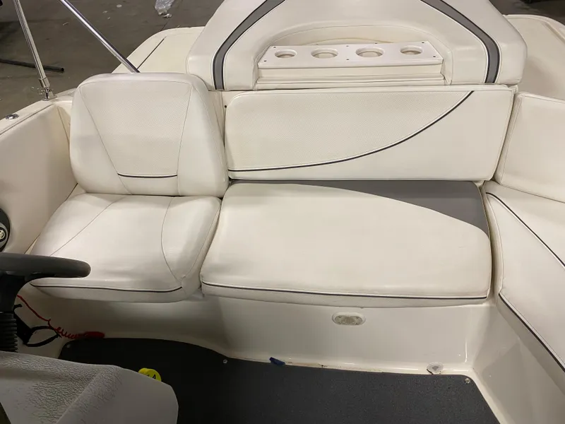 Slide: The Image of 2011 Bayliner 197 boat interior with white cushioned seating and cup holders. - 13