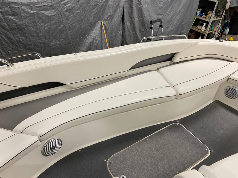 Slide: The Image of 2011 Bayliner 197 boat interior with white cushioned seating and built-in speakers. - 19