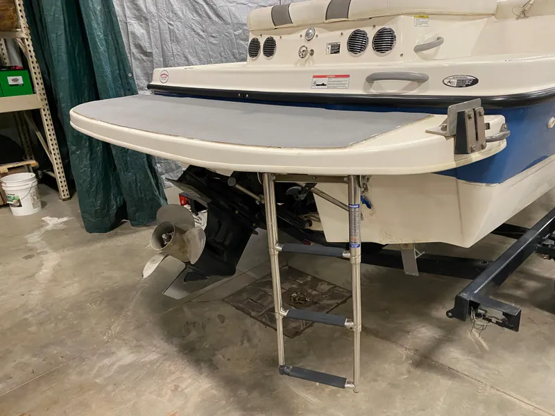 Slide: The Image of 2011 Bayliner 197 boat stern with swim platform and ladder in a garage. - 4