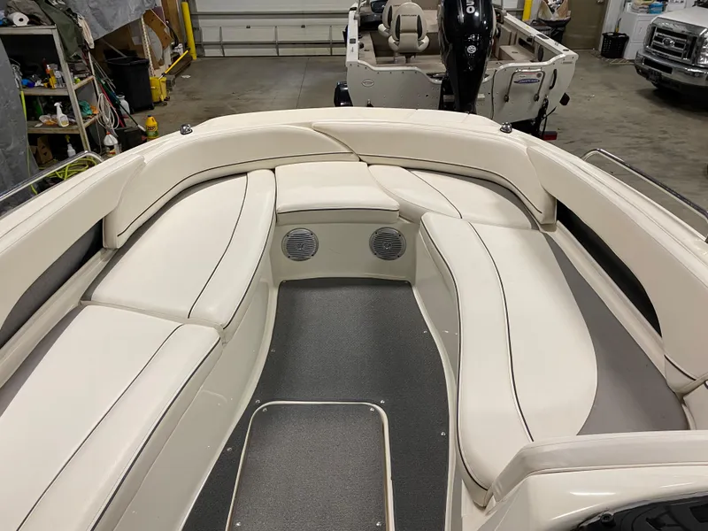 Slide: The Image of 2011 Bayliner 197 boat interior with white cushioned seating in a garage. - 6