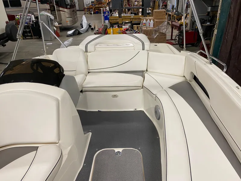 Slide: The Image of 2011 Bayliner 197 boat interior with white seating and gray flooring in a workshop. - 7