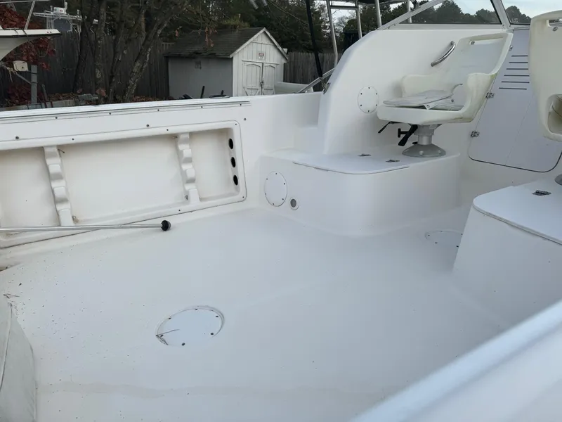 Slide: The Image of 2006 Pro-Line 23 Walk boat interior with white seating and storage compartments. - 19