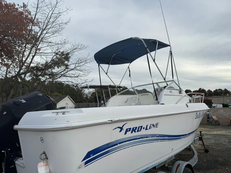 Slide: The Image of 2006 Pro-Line 23 Walk boat with blue canopy on trailer. - 20