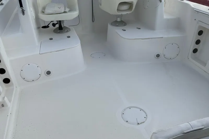 Slide: The Image of 2006 Pro-Line 23 Walk boat interior with white seating and deck. - 23