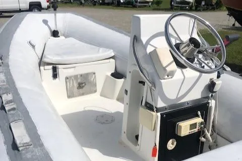 Slide: The Image of 1995 Novurania Tender boat with steering wheel and seating area. - 6