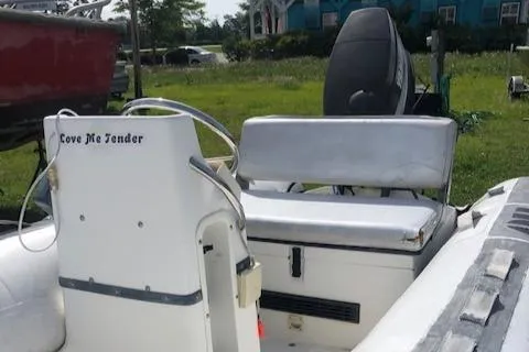 Slide: The Image of 1995 Novurania Tender boat with white seating and steering console, parked outdoors. - 7