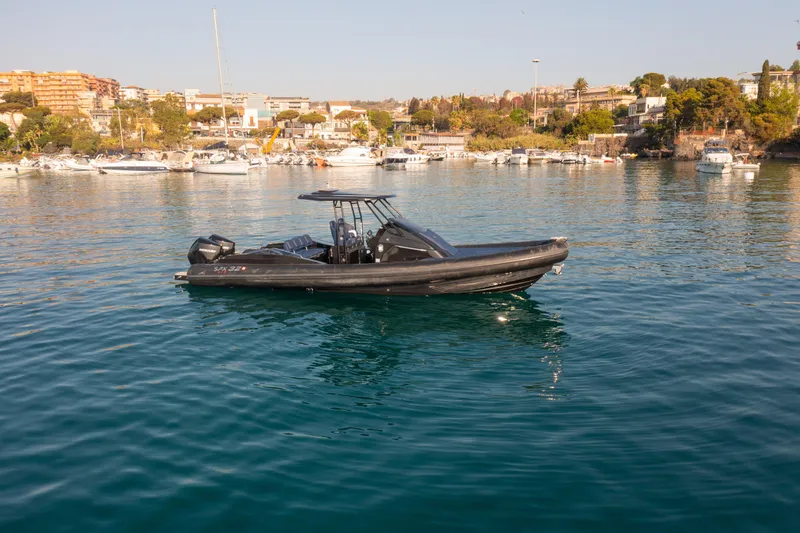 The Image of 2025 SPX RIB 32 Dinette boat on calm water near marina. - 0