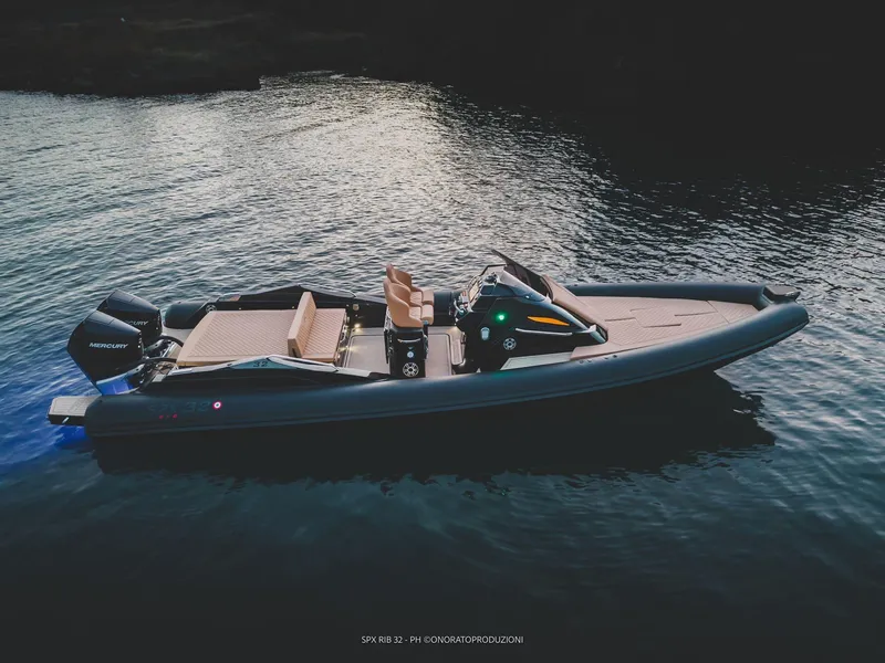 Slide: The Image of 2025 SPX RIB 32 Sport boat on calm water at dusk. - 10