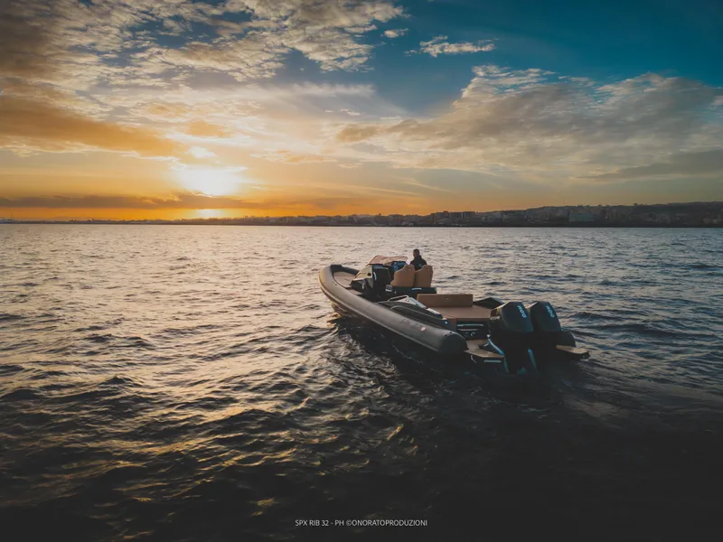 Slide: The Image of SPX RIB 32 Dinette 2025 boat cruising at sunset on open water. - 13