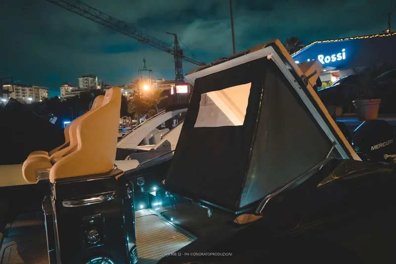 Slide: The Image of 2025 SPX RIB 32 Sport boat at night with illuminated interior. - 16