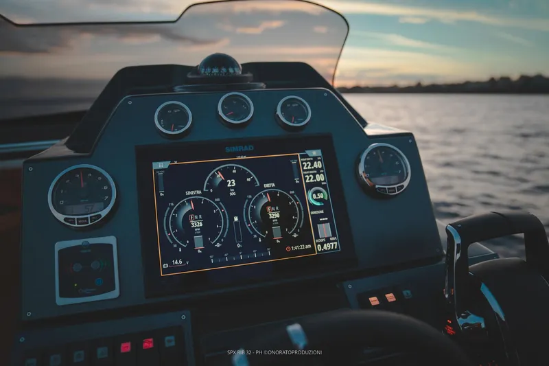 Slide: The Image of SPX RIB 32 Dinette 2025 dashboard with digital display at sunset on water. - 20