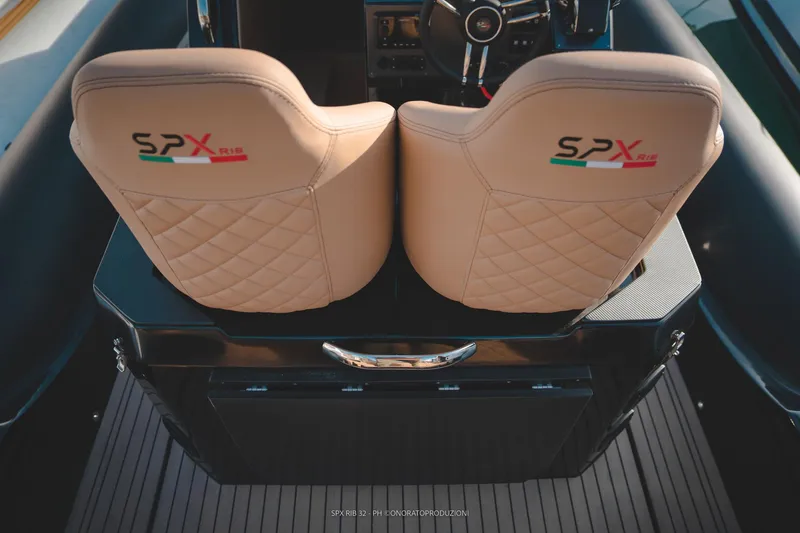 Slide: The Image of 2025 SPX RIB 32 Dinette boat interior with quilted seats and steering wheel. - 26