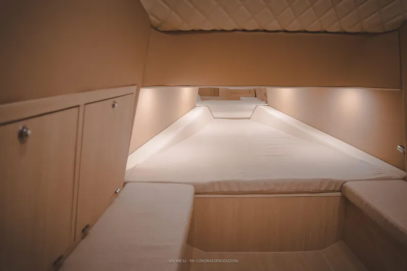 Slide: The Image of Interior cabin of 2025 SPX RIB 32 Sport boat with cozy bed and storage cabinets. - 34