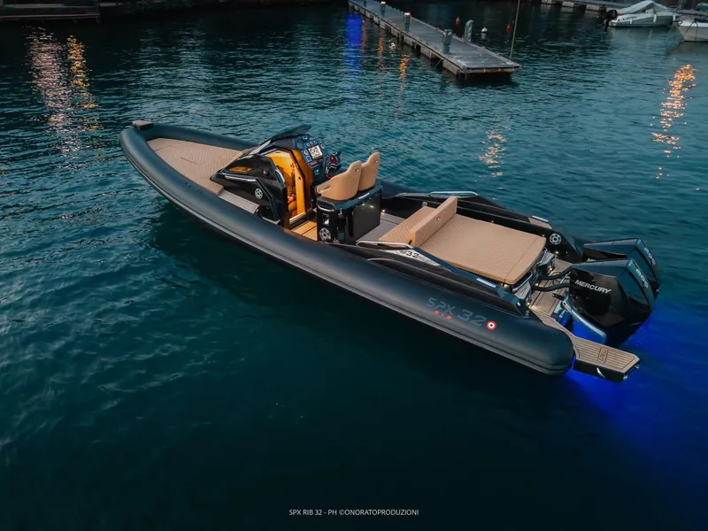 Slide: The Image of 2025 SPX RIB 32 Sport boat docked in calm waters at dusk. - 6