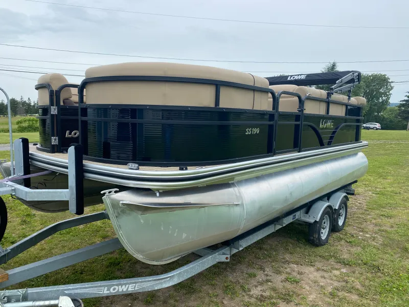 The Image of 2020 Lowe SS 190 Pontoon boat on trailer in grassy area. - 0