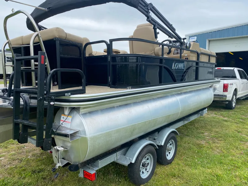 Slide: The Image of 2020 Lowe SS 190 Pontoon boat on a trailer, parked on grass near a white truck. - 4