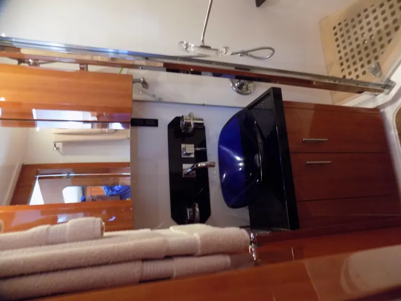 Slide: The Image of Luxurious bathroom in 2012 Regal 52 Sport Coupe yacht with modern fixtures and blue basin. - 10