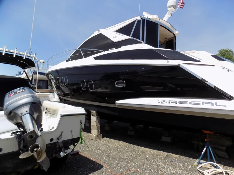Slide: The Image of 2012 Regal 52 Sport Coupe yacht on dry dock, black and white exterior. - 3