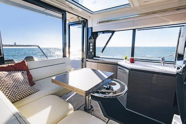 Slide: The Image of Interior of 2024 Wellcraft 355 yacht with ocean view, modern seating, and dining area. - 4