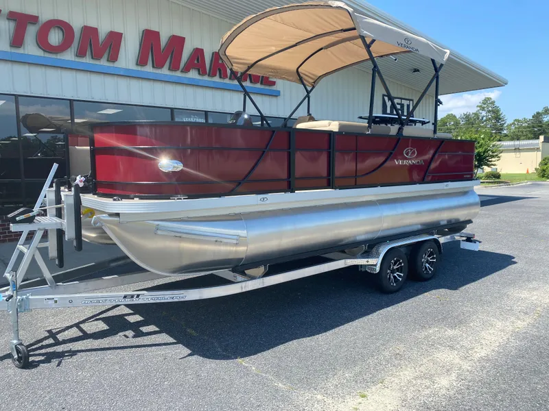 Slide: The Image of 2023 Veranda Fish VF20F4 pontoon boat on a trailer outside a marine dealership. - 2