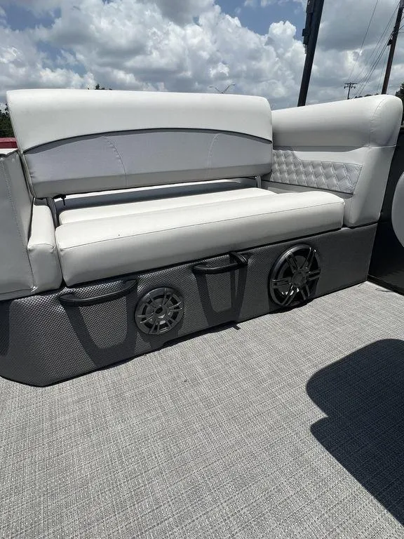 Slide: The Image of 2022 Crest Classic DLX 240 SLSC boat with white cushioned seating and built-in speakers. - 3