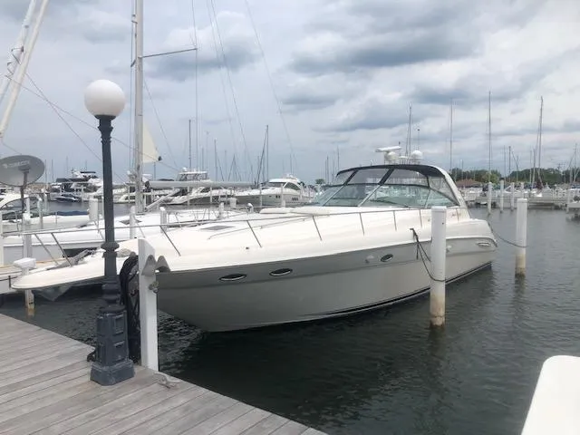 The Image of 2000 Sea Ray Sundancer yacht docked at a marina under cloudy skies. - 0
