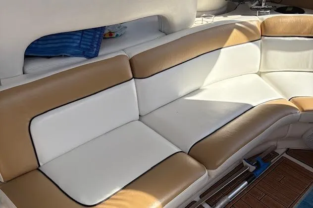 Slide: The Image of 2000 Sea Ray Sundancer boat interior with tan and white cushioned seating. - 48