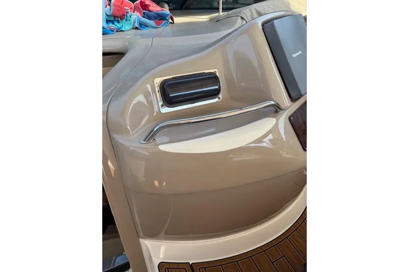 Slide: The Image of 2000 Sea Ray Sundancer boat interior with beige dashboard and colorful towels. - 50