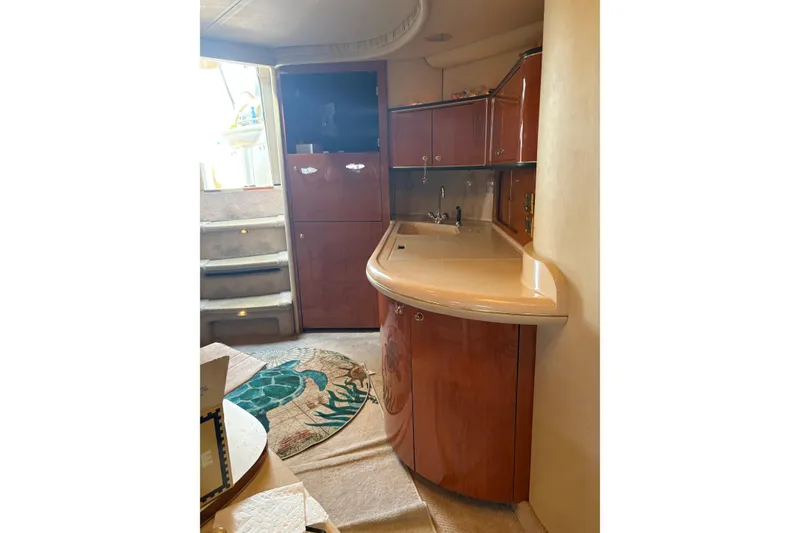 Slide: The Image of Interior of 2000 Sea Ray 460 Sundancer yacht with wooden cabinetry and compact kitchen area. - 60