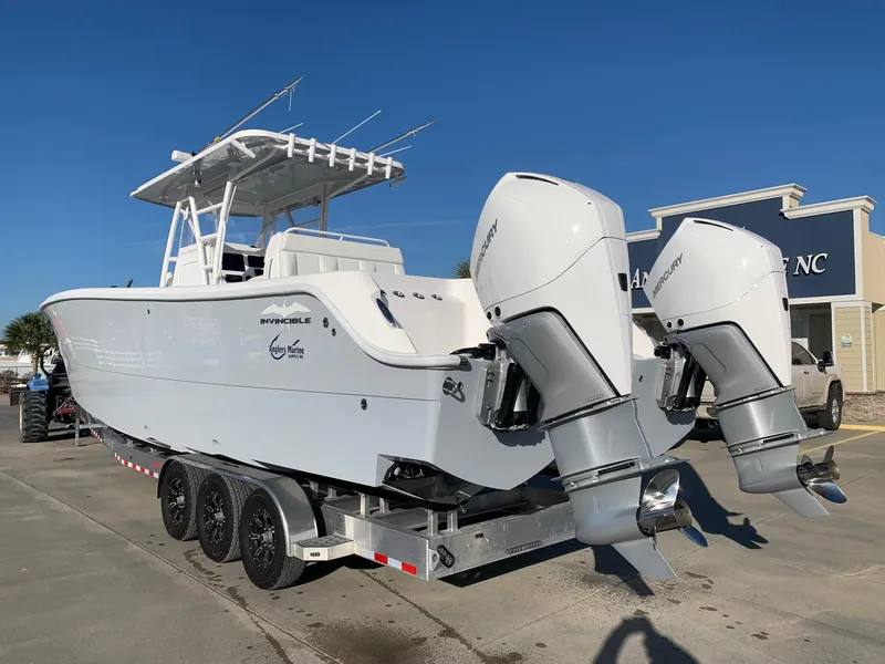 Slide: The Image of 2024 Invincible 33 Catamaran boat on a trailer with twin outboard engines. - 1